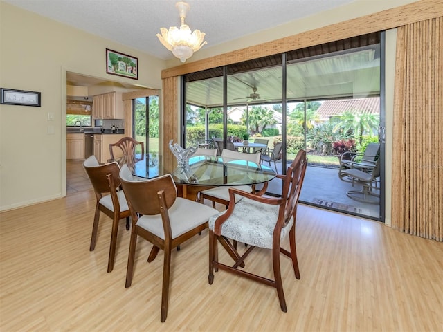 154 Inlets Blvd, Nokomis, FL 34275 - dining space with light wood finished floors, plenty of natural light, a chandelier, and a textured ceiling