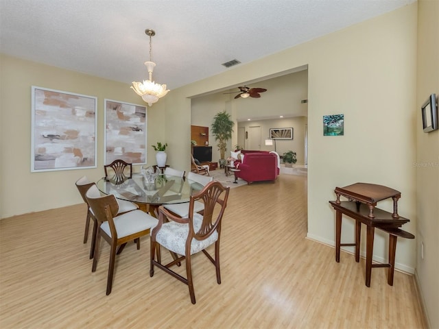 154 Inlets Blvd, Nokomis, FL 34275 - dining room with light wood-style flooring, a chandelier, and a ceiling fan