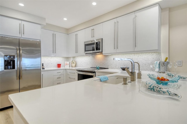 1000 Longboat Club Rd Unit 1105, Longboat Key, FL 34228 - kitchen featuring stainless steel appliances, light countertops, decorative backsplash, white cabinetry, and recessed lighting