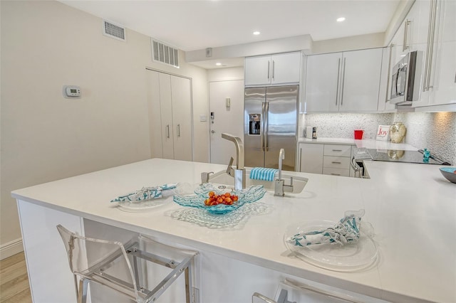 1000 Longboat Club Rd Unit 1105, Longboat Key, FL 34228 - kitchen featuring appliances with stainless steel finishes, light countertops, a peninsula, decorative backsplash, and recessed lighting