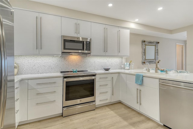 1000 Longboat Club Rd Unit 1105, Longboat Key, FL 34228 - kitchen featuring appliances with stainless steel finishes, light countertops, light wood-type flooring, tasteful backsplash, and recessed lighting