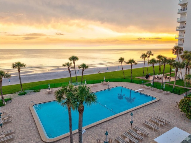 1000 Longboat Club Rd Unit 1105, Longboat Key, FL 34228 - pool at dusk featuring a water view, a community pool, and a patio area