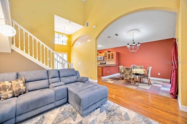 4127 Middle River Ter, Ellenton, FL 34222 - living area with a chandelier, wood finished floors, arched walkways, stairs, and a high ceiling