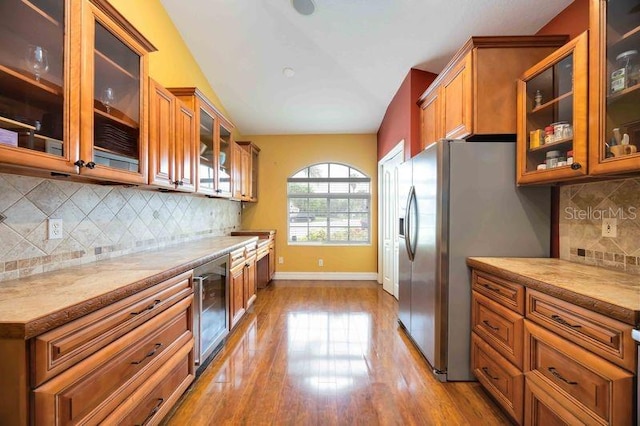 4127 Middle River Ter, Ellenton, FL 34222 - kitchen featuring wine cooler, brown cabinetry, stainless steel fridge with ice dispenser, light wood-style floors, and glass insert cabinets