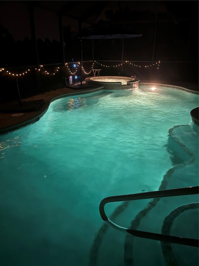 4127 Middle River Ter, Ellenton, FL 34222 - pool at twilight featuring glass enclosure and a pool with connected hot tub