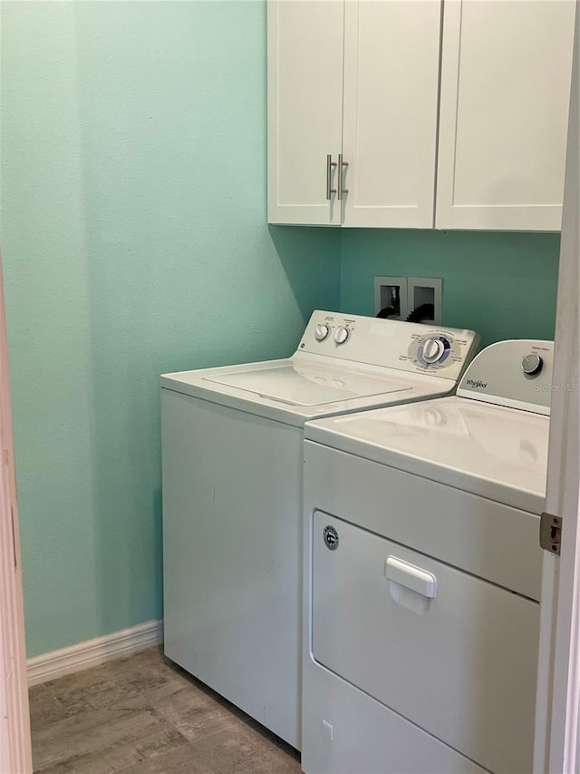 5635 Los Robles Ct, Palmetto, FL 34221 - laundry room with washer and clothes dryer, cabinet space, and light wood-type flooring