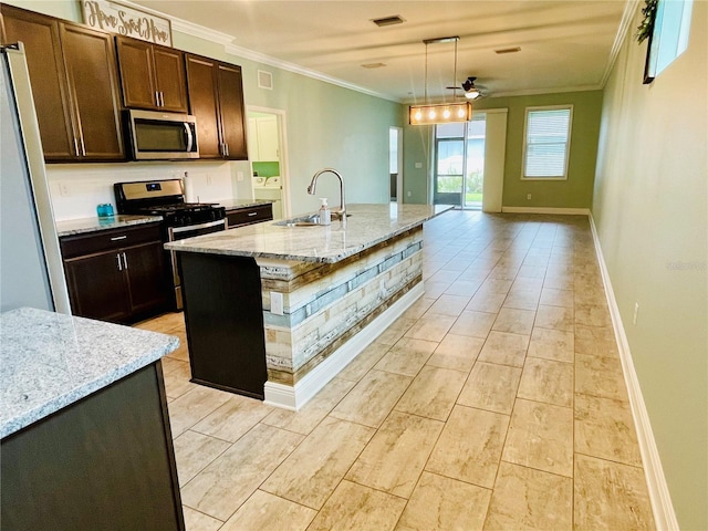 5635 Los Robles Ct, Palmetto, FL 34221 - kitchen featuring stainless steel microwave, crown molding, light stone countertops, decorative light fixtures, and dark brown cabinets