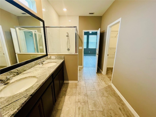 5635 Los Robles Ct, Palmetto, FL 34221 - bathroom with a shower stall, double vanity, a walk in closet, and wood finished floors