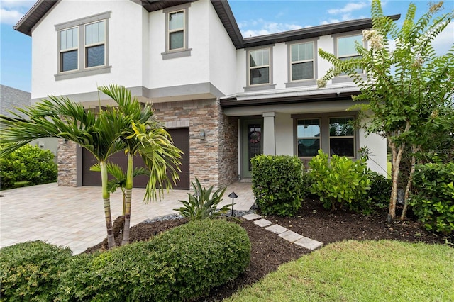 731 116th Ct NE, Bradenton, FL 34212 - view of front of house featuring stucco siding, stone siding, a garage, driveway, and a porch