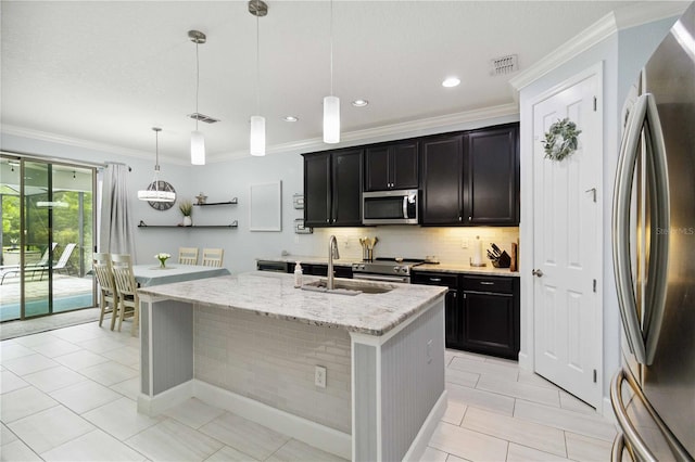 731 116th Ct NE, Bradenton, FL 34212 - kitchen featuring stainless steel appliances, tasteful backsplash, a center island with sink, crown molding, and light stone counters