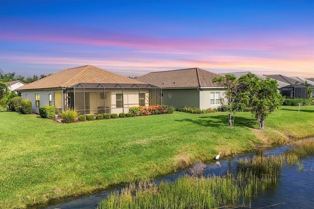 12641 Coastal Breeze Way, Bradenton, FL 34211 - back of property with a tile roof, a yard, and stucco siding