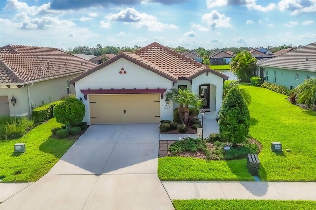 12641 Coastal Breeze Way, Bradenton, FL 34211 - mediterranean / spanish house with concrete driveway, a garage, a residential view, a front yard, and stucco siding