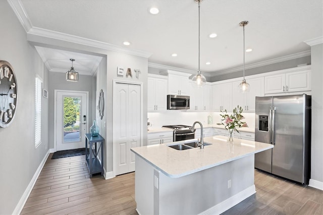 12641 Coastal Breeze Way, Bradenton, FL 34211 - kitchen with appliances with stainless steel finishes, light wood-type flooring, white cabinetry, an island with sink, and crown molding