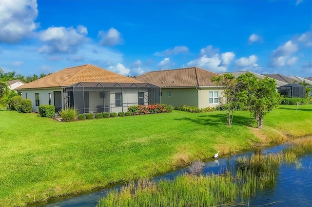 12641 Coastal Breeze Way, Bradenton, FL 34211 - rear view of property with a tile roof, a lawn, and stucco siding