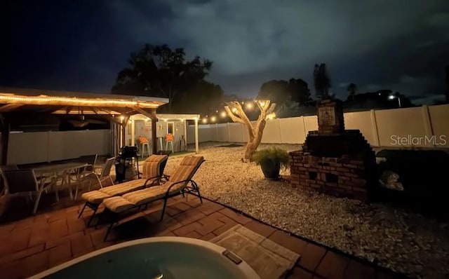 3614 29th Ave W, Bradenton, FL 34205 - patio at twilight featuring a patio, a fenced backyard, a hot tub, and outdoor dining space
