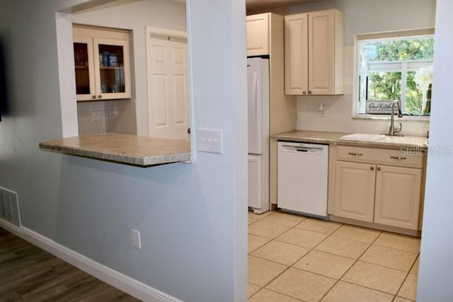 3614 29th Ave W, Bradenton, FL 34205 - kitchen with white appliances, tasteful backsplash, light countertops, and glass insert cabinets