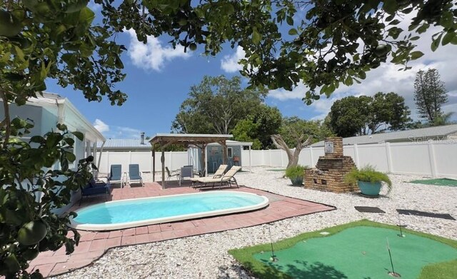 3614 29th Ave W, Bradenton, FL 34205 - view of swimming pool featuring a putting area, a fenced backyard, a patio, and a storage unit