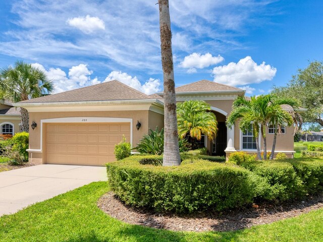 280 Dahlia Ct, Bradenton, FL 34212 - view of front of home with stucco siding, an attached garage, and driveway
