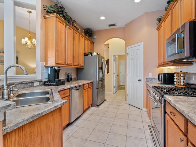 280 Dahlia Ct, Bradenton, FL 34212 - kitchen featuring stainless steel appliances, backsplash, light tile patterned flooring, light countertops, and arched walkways