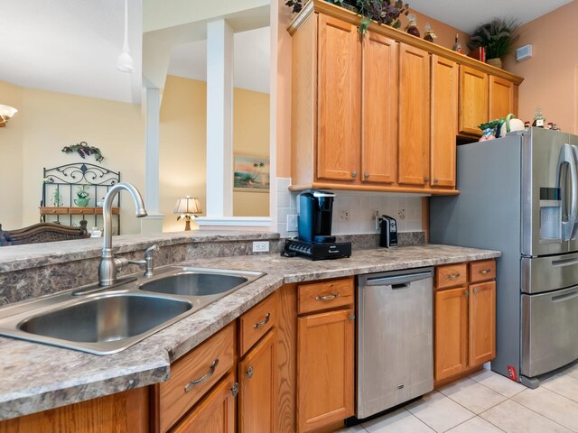 280 Dahlia Ct, Bradenton, FL 34212 - kitchen featuring stainless steel appliances, light tile patterned flooring, brown cabinets, and backsplash
