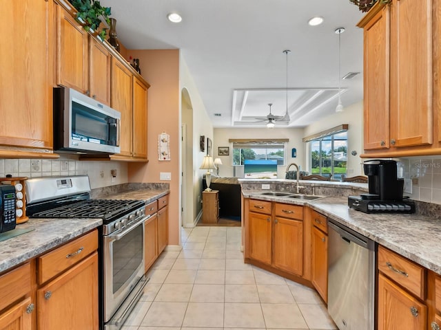 280 Dahlia Ct, Bradenton, FL 34212 - kitchen with stainless steel appliances, open floor plan, a tray ceiling, tasteful backsplash, and ceiling fan