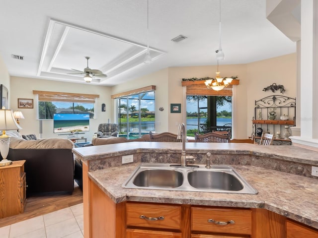 280 Dahlia Ct, Bradenton, FL 34212 - kitchen with open floor plan, a chandelier, a raised ceiling, and brown cabinetry