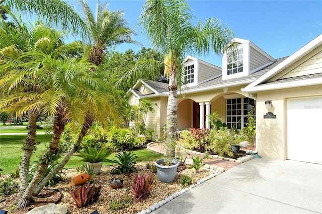 730 137th St NE, Bradenton, FL 34212 - property entrance with roof with shingles, stucco siding, driveway, and an attached garage