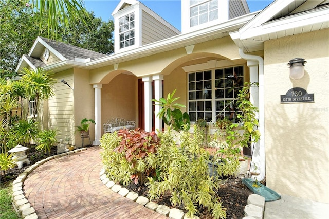 730 137th St NE, Bradenton, FL 34212 - view of exterior entry with stucco siding and a shingled roof