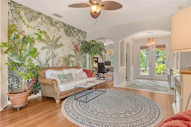 730 137th St NE, Bradenton, FL 34212 - living area with arched walkways, light wood-style floors, a ceiling fan, a desk, and wallpapered walls