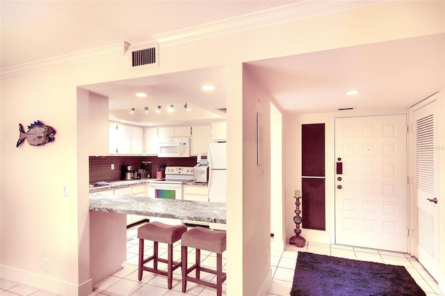2039 Gulf Of Mexico Dr Unit G3-207, Longboat Key, FL 34228 - kitchen featuring white appliances, ornamental molding, light tile patterned floors, white cabinets, and a breakfast bar area