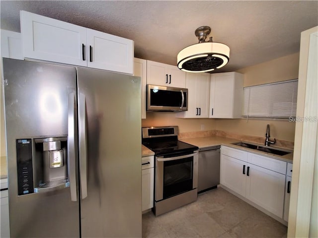 2763 Woodgate Ln Unit 105, Sarasota, FL 34231 - kitchen with stainless steel appliances, white cabinets, and light countertops