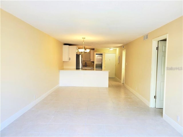 2763 Woodgate Ln Unit 105, Sarasota, FL 34231 - unfurnished living room featuring light tile patterned floors and a chandelier