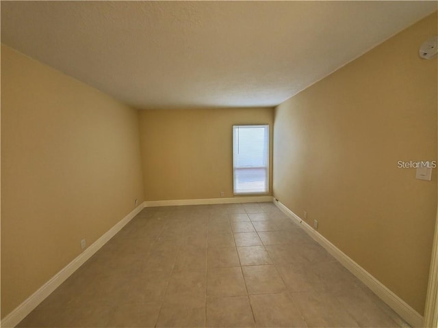 2763 Woodgate Ln Unit 105, Sarasota, FL 34231 - spare room with light tile patterned floors and baseboards