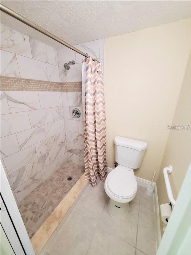 2763 Woodgate Ln Unit 105, Sarasota, FL 34231 - bathroom featuring tiled shower, a textured ceiling, and tile patterned flooring