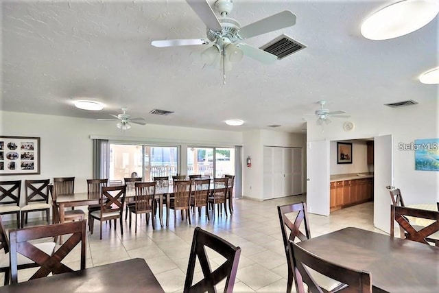 2763 Woodgate Ln Unit 105, Sarasota, FL 34231 - dining space featuring a ceiling fan, light tile patterned flooring, and a textured ceiling