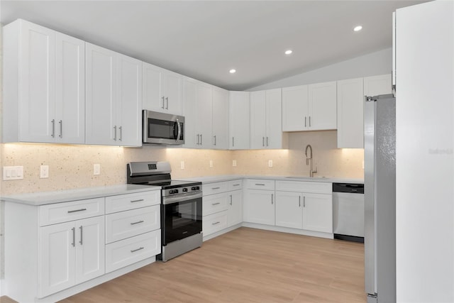 4515 19th Ave W, Bradenton, FL 34209 - kitchen with stainless steel appliances, decorative backsplash, light wood-style floors, light countertops, and white cabinets