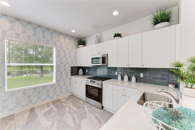 11431 Piedmont Park Xing, Bradenton, FL 34211 - kitchen with appliances with stainless steel finishes, wallpapered walls, light countertops, white cabinets, and recessed lighting