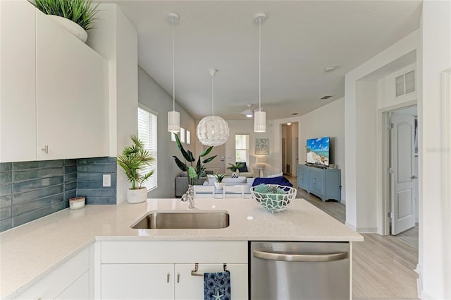 11431 Piedmont Park Xing, Bradenton, FL 34211 - kitchen with stainless steel dishwasher, light wood-type flooring, a peninsula, open floor plan, and backsplash