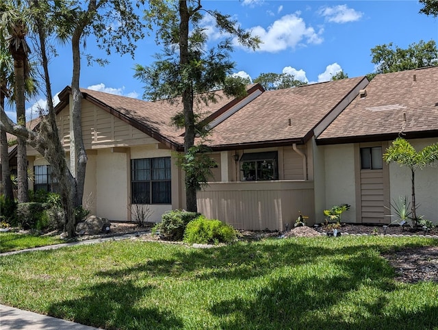 5231 Brassy Loop, North Port, FL 34287 - view of front facade with stucco siding, a shingled roof, and a front yard