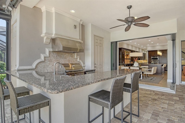 7638 Windy Hill Cv, Bradenton, FL 34202 - kitchen with backsplash, ceiling fan, healthy amount of natural light, a kitchen breakfast bar, and recessed lighting