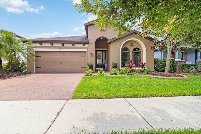 4044 Wisdom Trl, Land O Lakes, FL 34638 - mediterranean / spanish house featuring decorative driveway, an attached garage, stucco siding, and a front yard