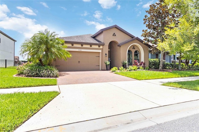 4044 Wisdom Trl, Land O Lakes, FL 34638 - mediterranean / spanish house featuring decorative driveway, stucco siding, and a garage