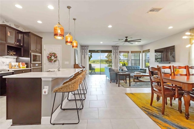 4044 Wisdom Trl, Land O Lakes, FL 34638 - kitchen with light countertops, recessed lighting, dark brown cabinetry, ceiling fan, and glass insert cabinets