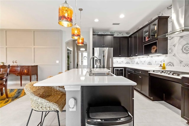 4044 Wisdom Trl, Land O Lakes, FL 34638 - kitchen with wall chimney range hood, stainless steel fridge, a kitchen breakfast bar, arched walkways, and light countertops