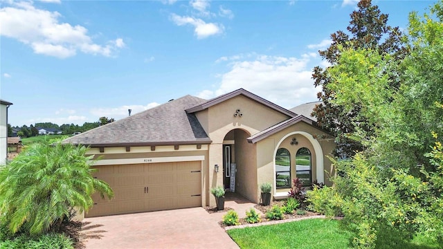 4044 Wisdom Trl, Land O Lakes, FL 34638 - view of front of property featuring stucco siding, an attached garage, decorative driveway, and roof with shingles