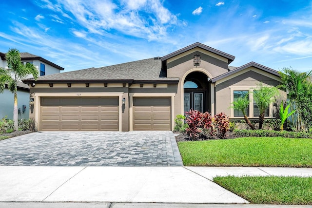 9215 Isabella Cir, Parrish, FL 34219 - view of front of home with decorative driveway, stucco siding, an attached garage, and a front lawn