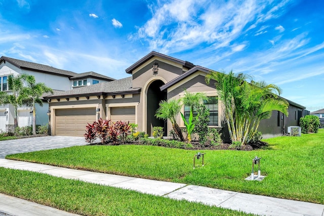 9215 Isabella Cir, Parrish, FL 34219 - view of front of property featuring stucco siding, decorative driveway, a garage, and a front lawn