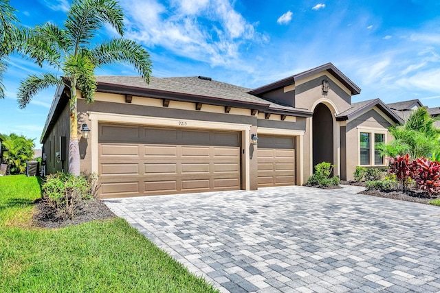 9215 Isabella Cir, Parrish, FL 34219 - view of front of home featuring stucco siding, decorative driveway, and an attached garage