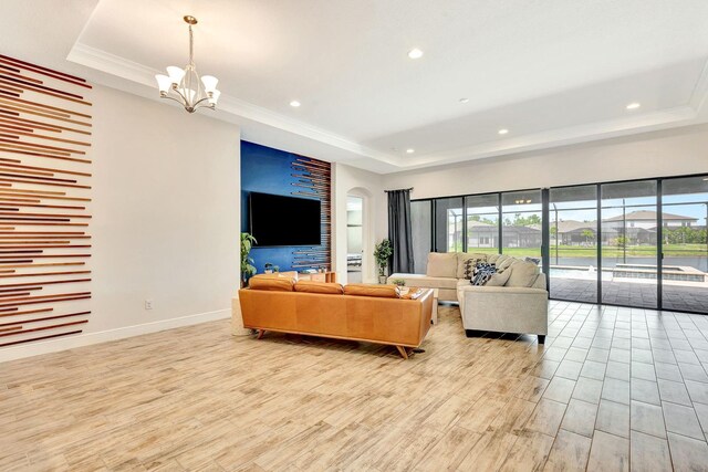 9215 Isabella Cir, Parrish, FL 34219 - living room featuring a raised ceiling, a chandelier, recessed lighting, light wood-style floors, and crown molding