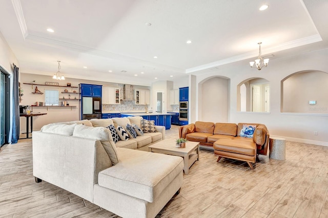 9215 Isabella Cir, Parrish, FL 34219 - living room featuring a raised ceiling, a chandelier, light wood finished floors, recessed lighting, and crown molding